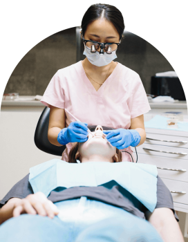 A dentist examining a patient in a dental chair at a Tooth Club clinic.